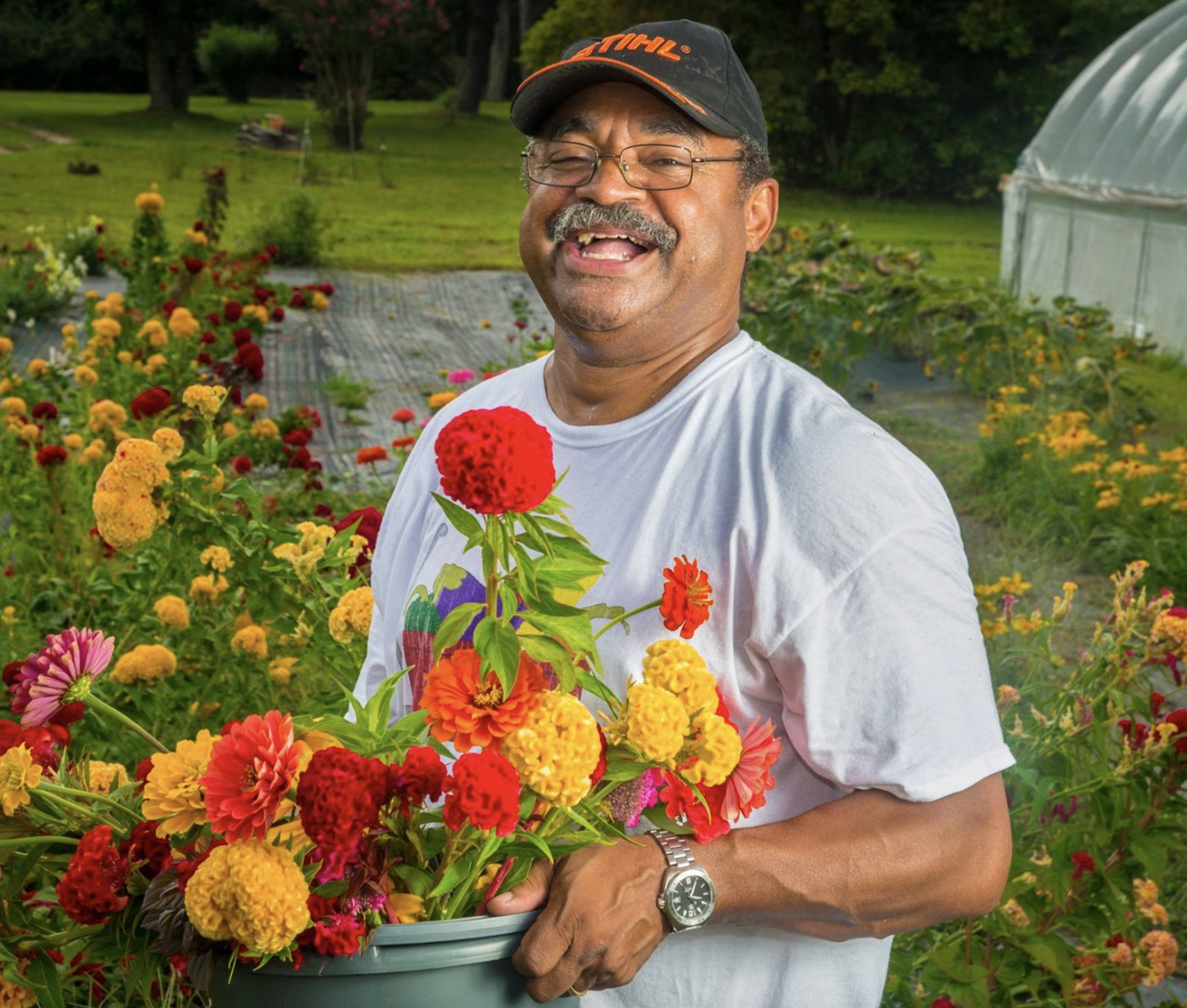 Farmer holds bucket of brightly colored flowers