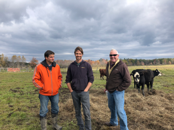 Tim Biello and farmers stand in pasture