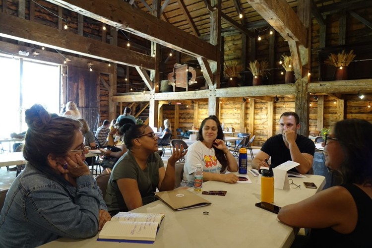 Attendees gather around a table in the barn.