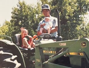 Paul Lum and his kids on tractor in 1990, Now he builds healthy soil across the state