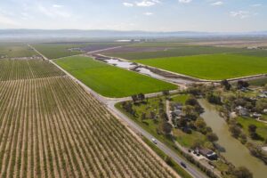 drone shot of San Joaquin Valley farmland, water and housing.