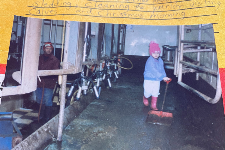 Olivia, 3 and a half years old, helps to clean the milking parlor as her dad looks on.