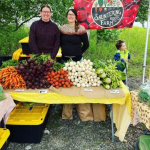 Two Alaskan women farmers at a produce stand.